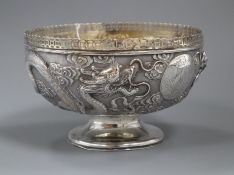 An early 20th century Chinese white metal pedestal bowl, embossed with dragons, 19cm, 13.5 oz.