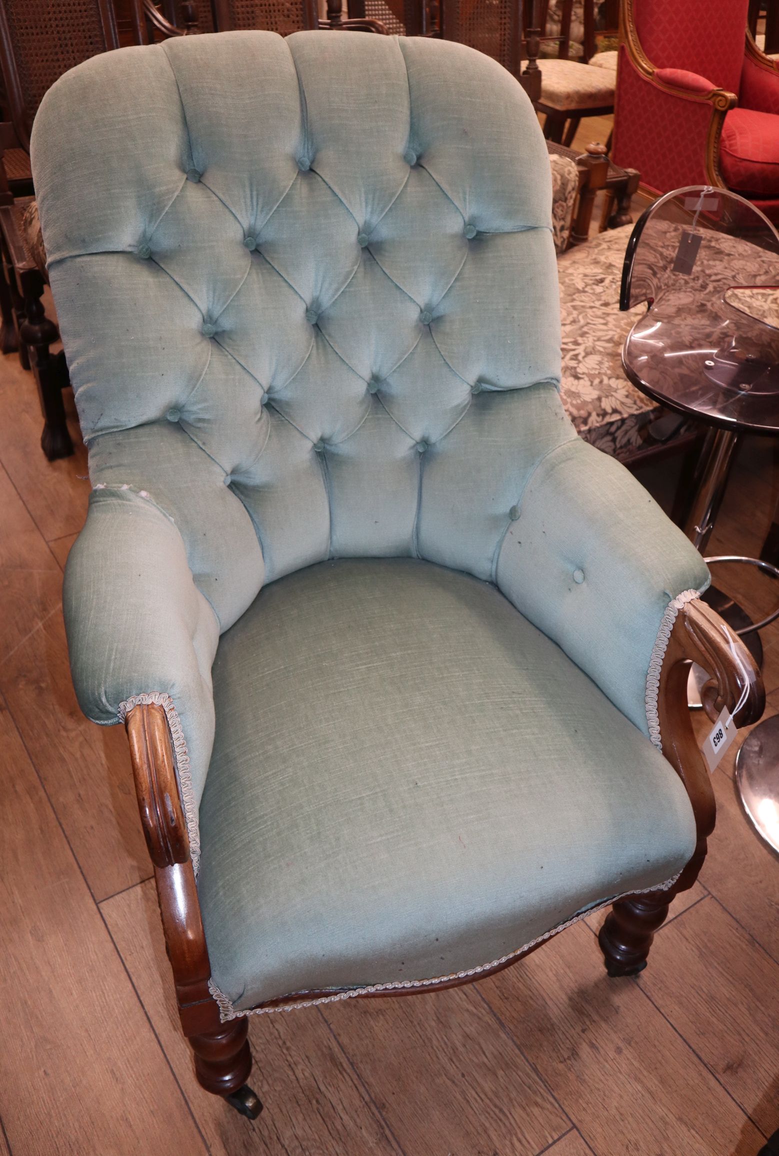 A Victorian mahogany spoonback armchair, with buttoned green upholstery