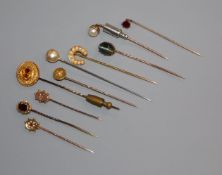 Ten assorted yellow metal and gem set stick pins.