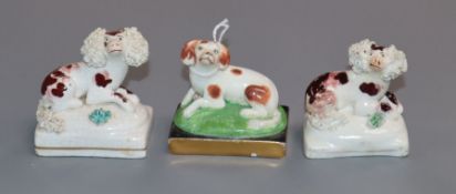 English porcelain figures of a pair of recumbent poodles and a King Charles spaniel, c.1830-50,