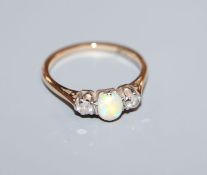 An '18ct and plat', white opal and diamond three stone ring, size K/L.