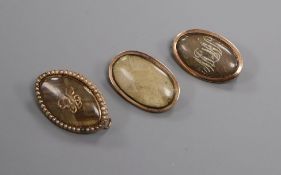 A George III yellow metal and plaited hair mourning brooch with inscription and two other mourning