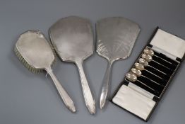 A set of six George V silver bean end coffee spoons, cased and three George V silver dressing