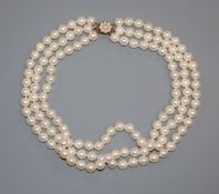 A triple strand cultured pearl choker necklace with yellow metal and cultured pearl set clasp,