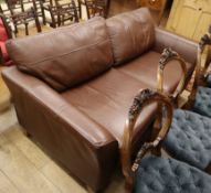 A modern brown leather two seater settee