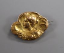 A French Art Nouveau repouse yellow metal brooch, decorated with the bust of a lady and bearing