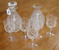 A set of five Stourbridge cut glass wine glasses and a pair of decanters, one lacking a stopper