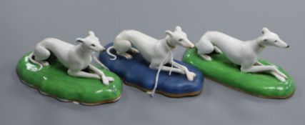 A pair of Staffordshire porcelain figures of recumbent greyhounds and another similar, c.1835-50,
