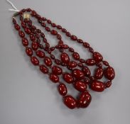 Two graduated simulated cherry amber bead necklaces, including one double strand, gross weight 129