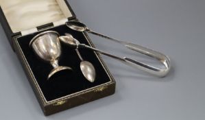 A pair of William IV silver fiddle pattern sugar tongs and a George V silver egg cup and spoon (