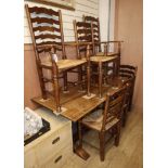 A 1920's oak refectory dining table and six rustic ladder back chairs, two with arms table length
