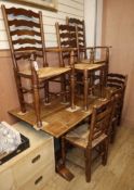 A 1920's oak refectory dining table and six rustic ladder back chairs, two with arms table length