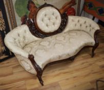 A Victorian carved and pierced settee upholstered in deep-buttoned ivory damask W.190cm