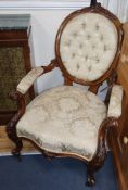 A Victorian carved round back armchair, upholstered in deep-buttoned ivory damask and a matching