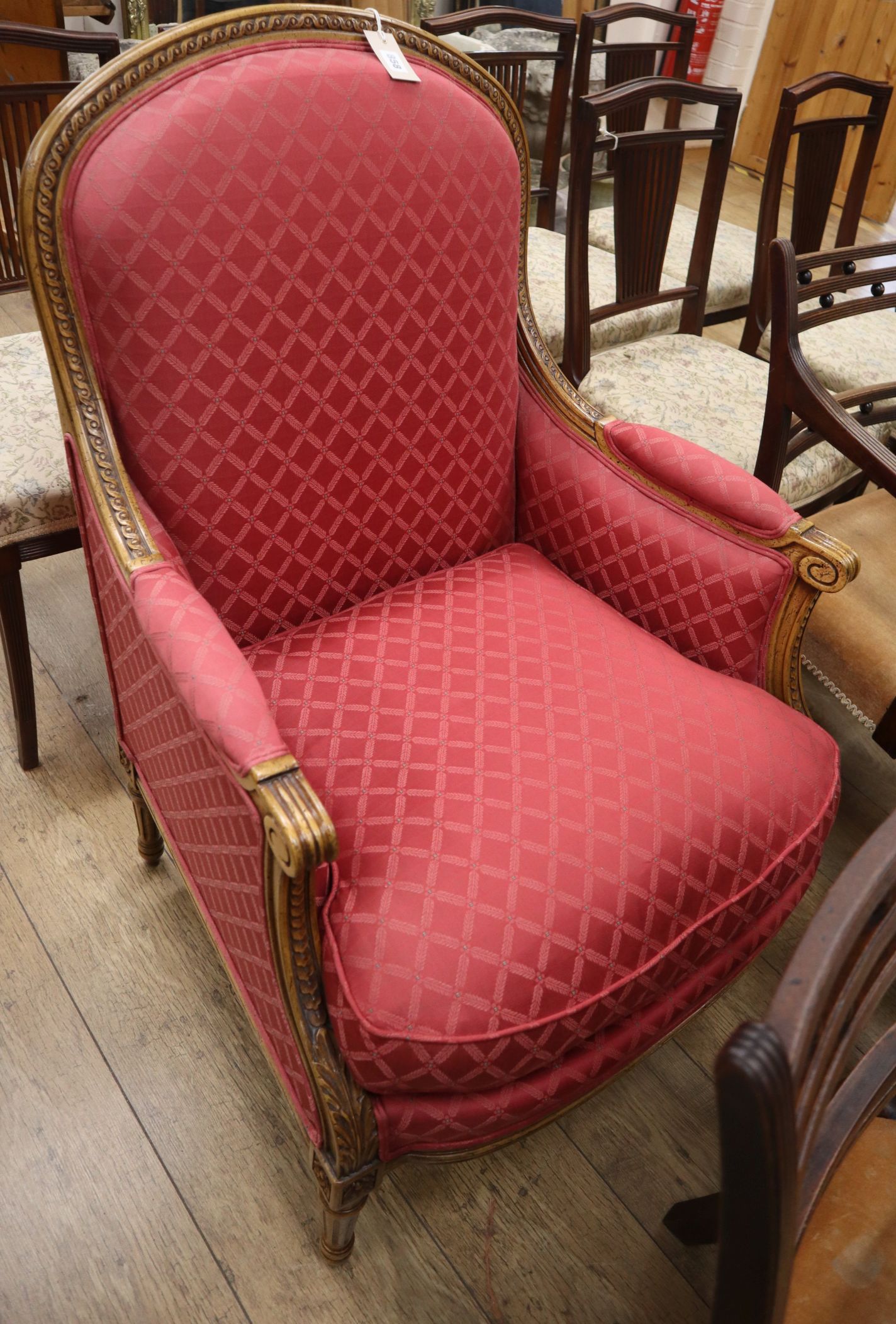 A Louis XVI design walnut armchair upholstered in red fabric