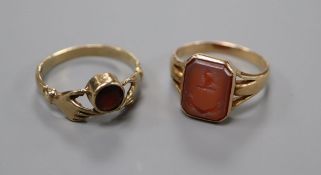 An early 20th century yellow metal and carved carnelian signet ring and a 9ct and garnet set twin