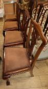 A set of four Chippendale style chairs with plain upholstered seats on cabriole legs with claw and