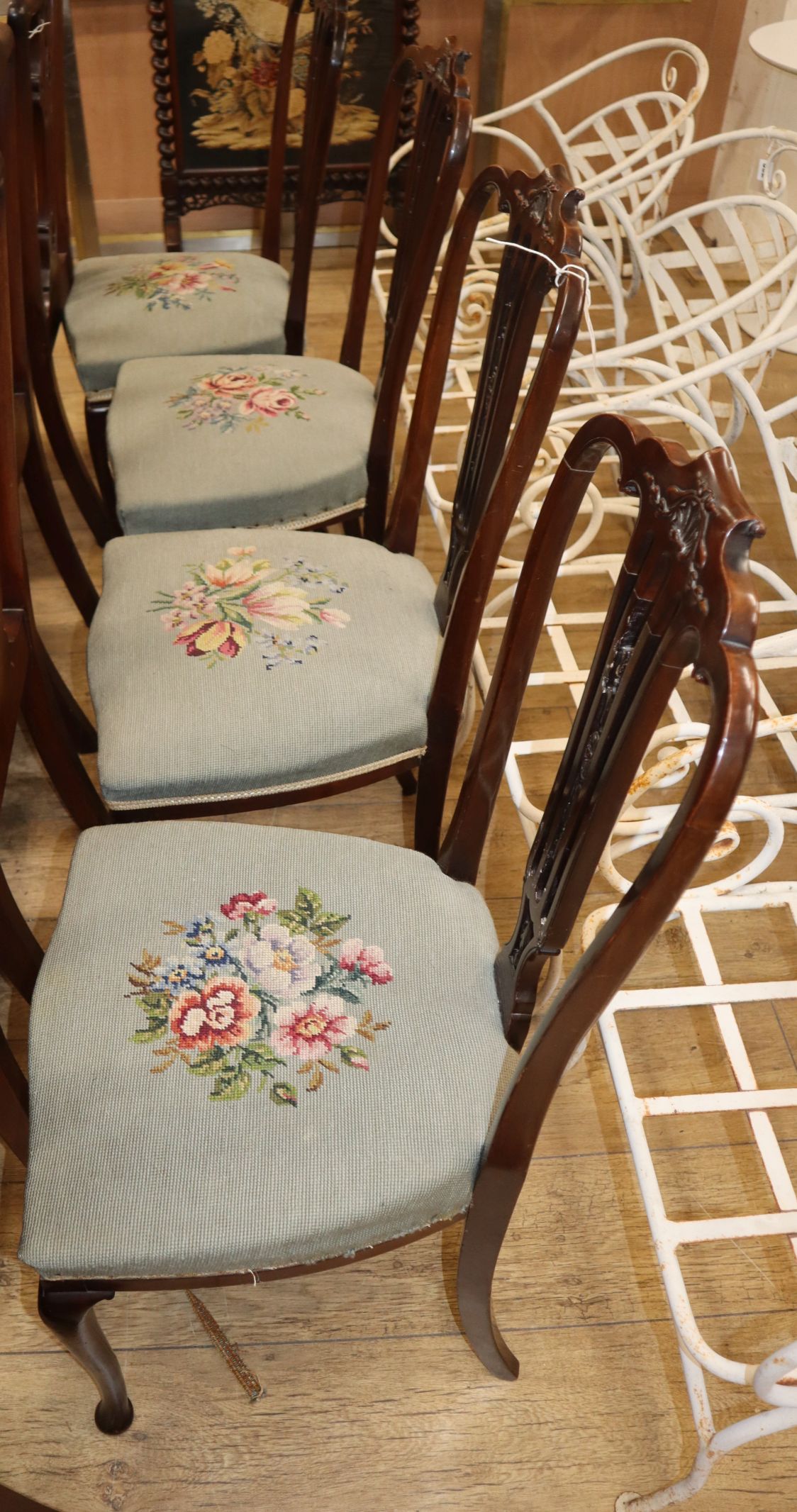 A set of four late Victorian salon chairs with pierced splats and floral tapestry seats