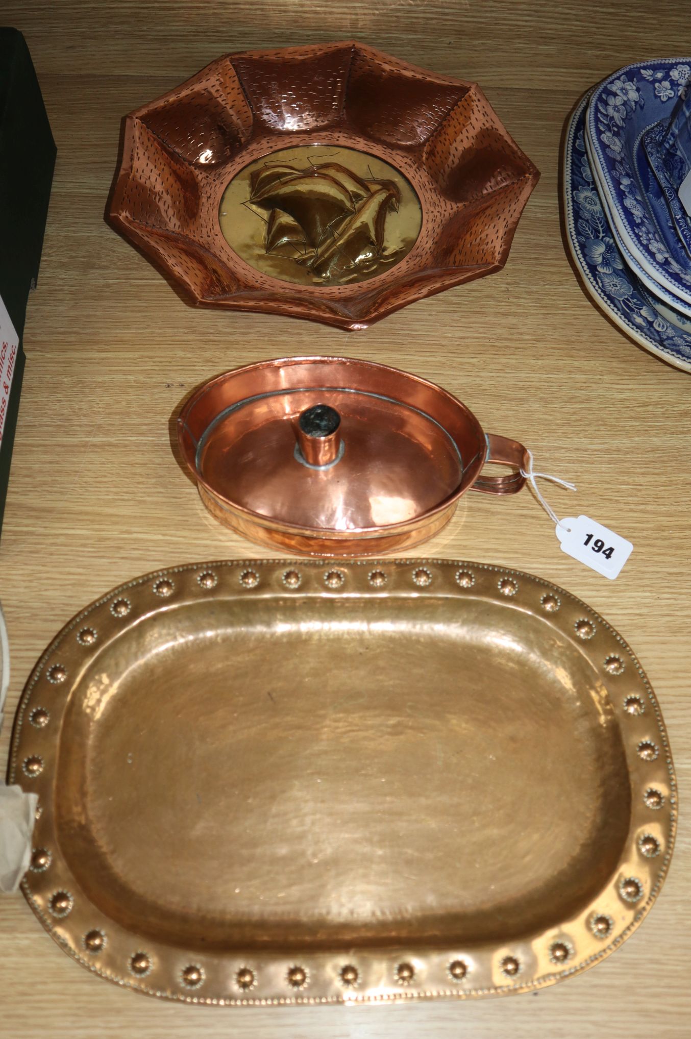 An Arts & Crafts copper candle holder, a copper and brass dish and a hammered brass dish