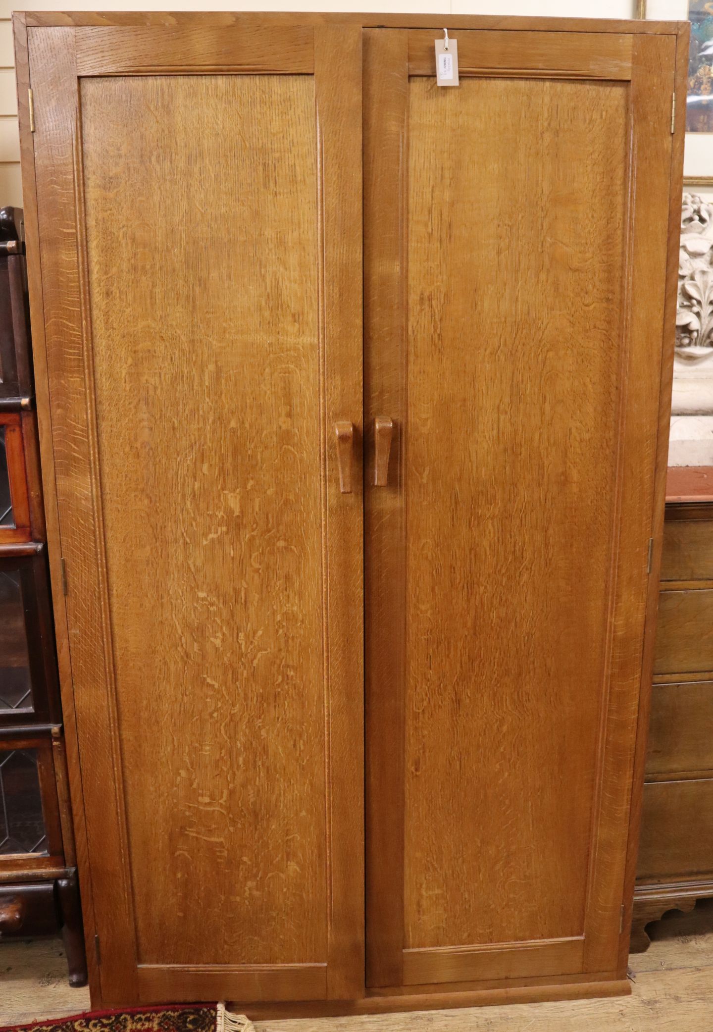 A panelled oak wardrobe and a matching night stand (reputed to be the work of John Skelton) Wardrobe