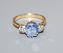 A modern 18ct gold, sapphire and diamond three stone ring, size O.