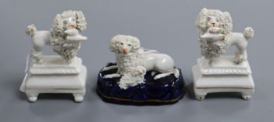 A pair of Staffordshire porcelain figures of poodles and a similar poodle group, c.1830-50, H. 6.2