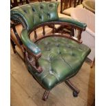A mahogany and green leather desk chair