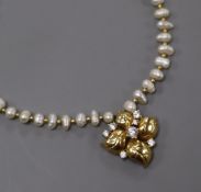An 18k yellow metal and diamond set pendant, on a baroque cultured pearl and yellow metal spacer