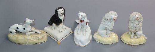 A pair of Samuel Alcock figures of seated poodles and three other Alcock type figures of dogs, c.