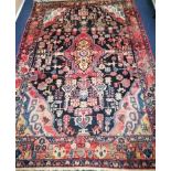 A Persian red ground rug with triple blue diagonal centre 245 x 189cm