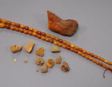 A graduated amber bead necklace and pieces of raw amber, gross weight 52 grams.