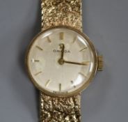 An Omega 9ct gold ladys' wristwatch on textured bracelet, boxed