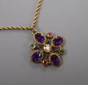 An Edwardian 9ct, amethyst and gem set quatrefoil pendant, on a yellow metal ropetwist chain,