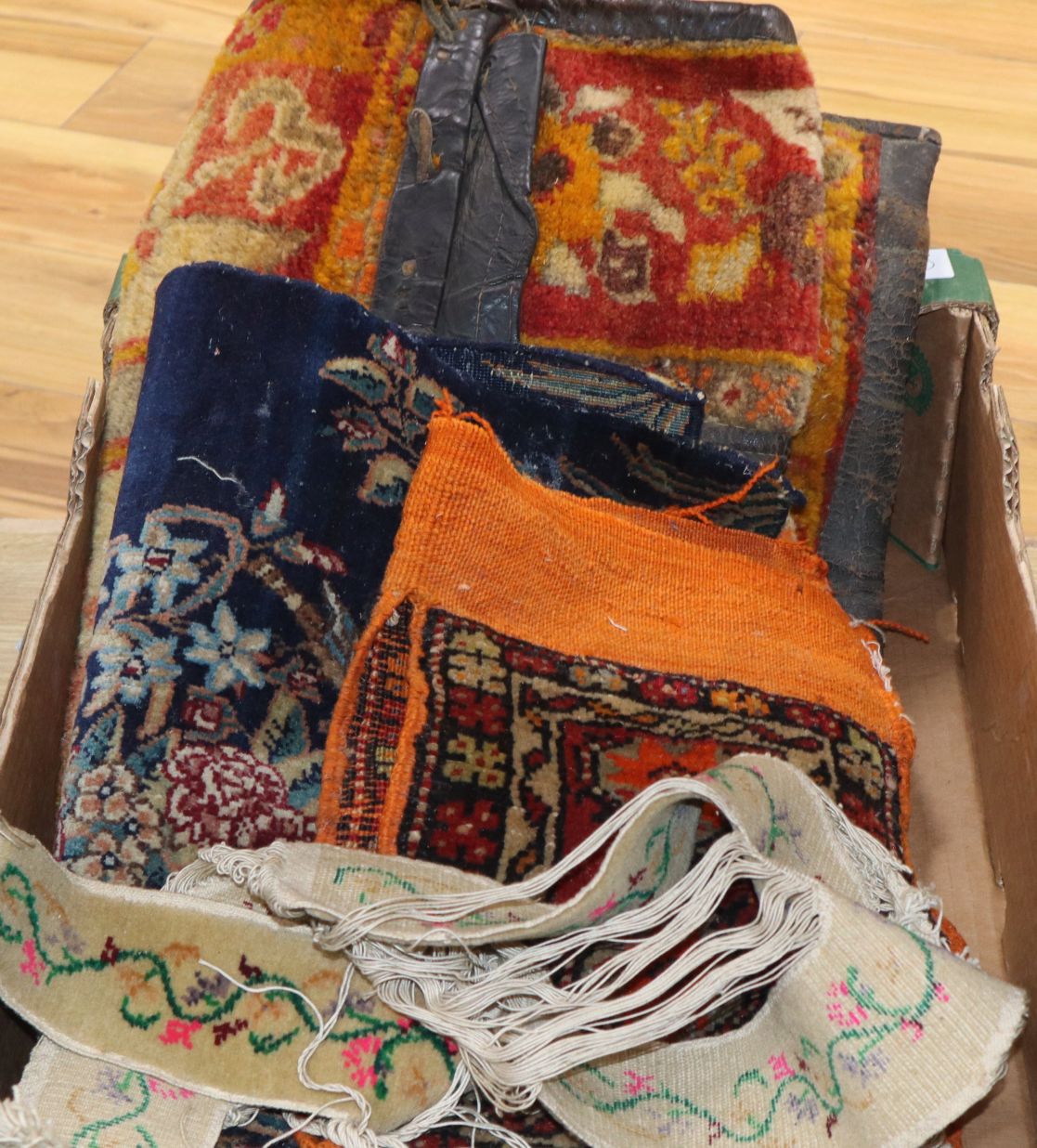 A carpet saddle bag, various carpet samples and carpet shoe uppers