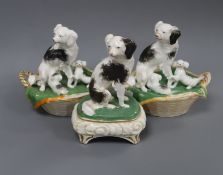 Two Staffordshire porcelain groups of a King Charles spaniel and puppies in a basket and a similar