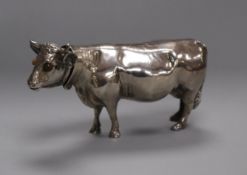 A Continental silver model of a standing cow having detachable head with glass eyes, indistinct