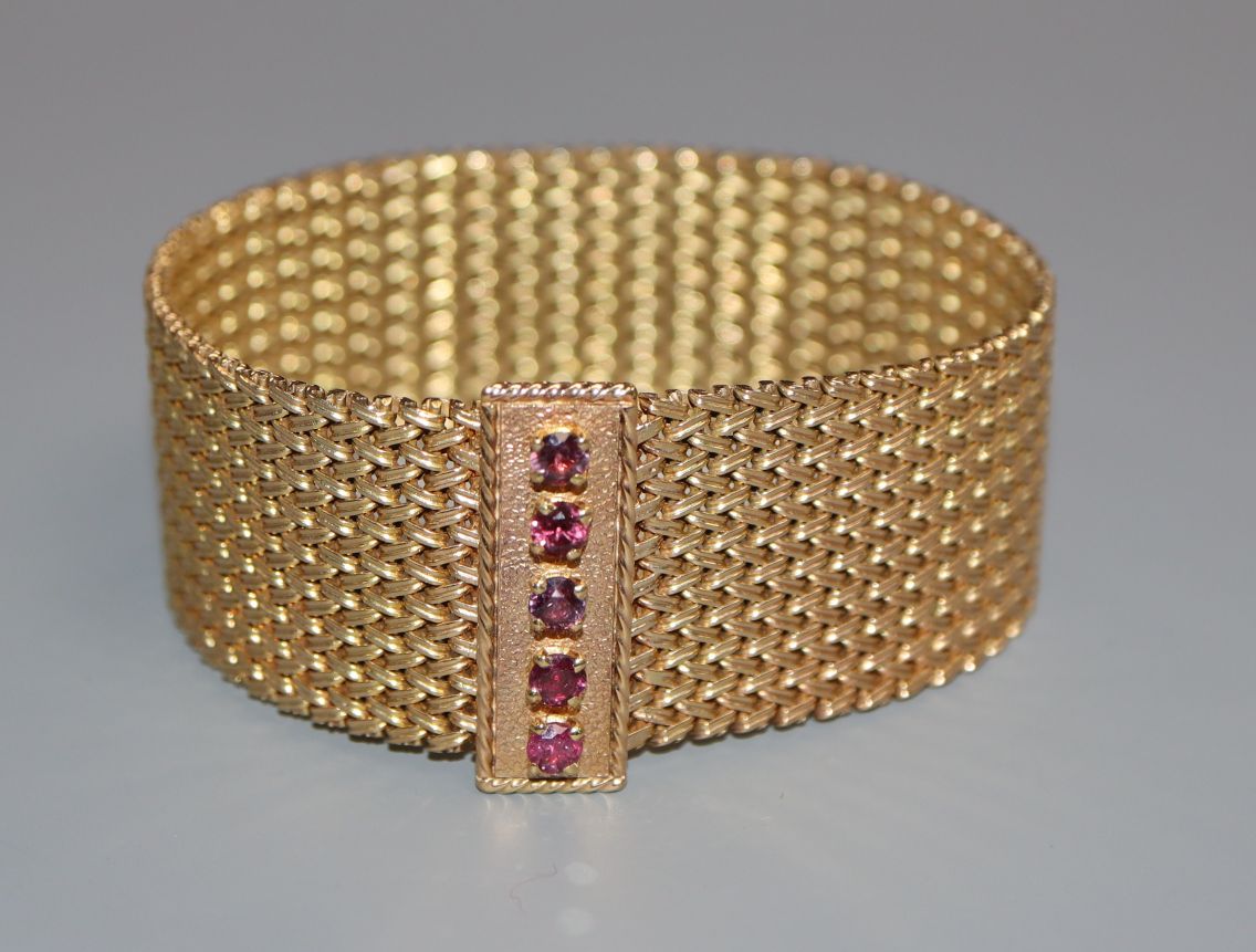 A 9ct gold milanese bracelet with ruby set clasp.