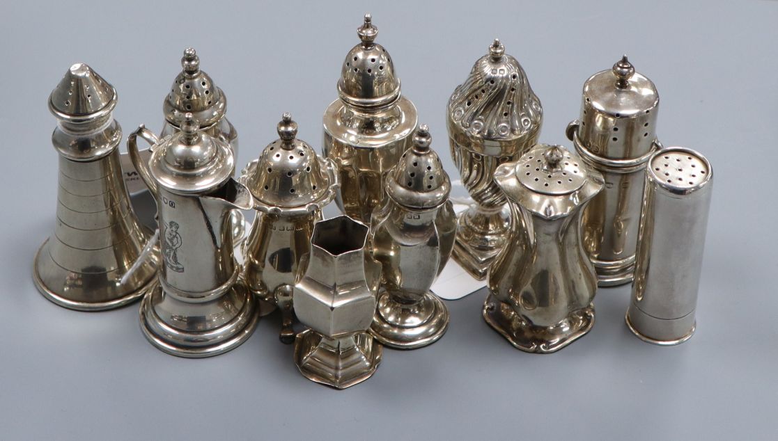 Eleven Victorian and later silver or white metal peppers, including lighthouse, cartridge,