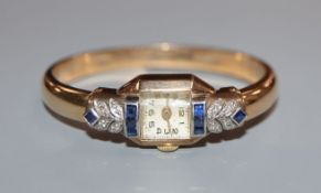 An Art Deco style 9ct gold, sapphire and diamond set bangle cocktail watch.