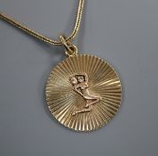 A 9ct gold 'water carrier' circular pendant, on a 375 chain, pendant 26mm.