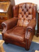 A modern buttoned leather wing armchair