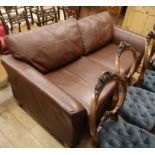 A modern brown leather two seater settee