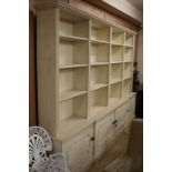 A George II style cream painted pine open bookcase cupboard W.310cm