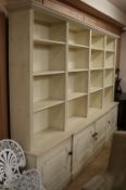 A George II style cream painted pine open bookcase cupboard W.310cm