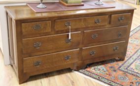 A reproduction oak seven drawer dresser base W.152cm