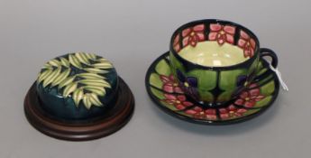 A Moorcroft Violets cup and saucer, seconds and a paperweight