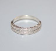 A white metal and twin row diamond set half hoop ring, size O.