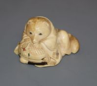 A Japanese Meiji period carved ivory netsuke of a fox cub on a cushion, with inset eyes 3.5cm high