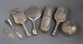 An Austro-Hungarian four piece white metal brush set and three other dressing items.