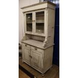 A pine dresser fitted a pair of glazed cupboards with distressed white-painted finish W.107cm
